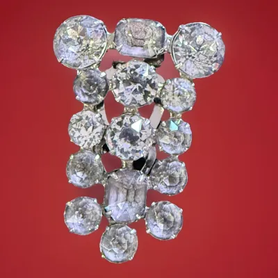 Sale Photo Thumbnail #56: A beautiful vintage rhinestone fur clip in the unmistakable Eisenberg style, featuring a bold, dimensional arrangement of faceted clear stones in a classic silver-tone setting. The design showcases a mix of round and rectangular cuts, creating depth, bril