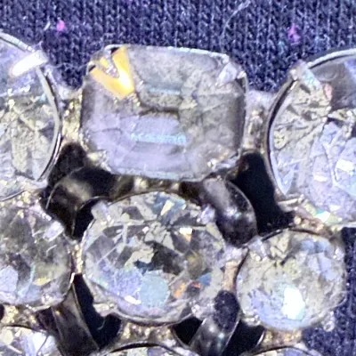 Sale Photo Thumbnail #57: A beautiful vintage rhinestone fur clip in the unmistakable Eisenberg style, featuring a bold, dimensional arrangement of faceted clear stones in a classic silver-tone setting. The design showcases a mix of round and rectangular cuts, creating depth, bril
