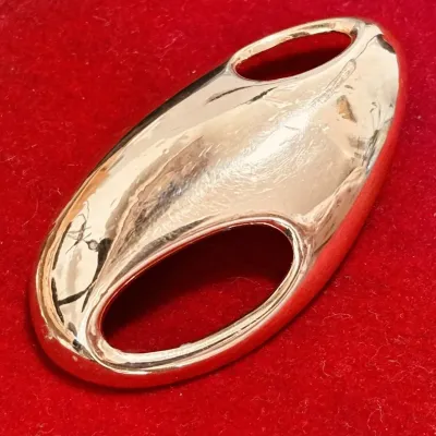 Sale Photo Thumbnail #148: This is a rare Trifari brooch from the 1970s designed by Kunio Matsumoto. It features a modernist abstract design in gold tone, measuring 2.5 inches in length. Signed by Trifari, this vintage piece is oval in shape and does not contain any stones. It is a