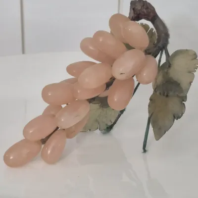 Sale Photo Thumbnail #276: This is a realistically carved rose jade bunch of grapes with darker jade carved leaves. The stem network is wire wrapped with blue satin cord and the end where it would have been cut from the vine is faux wood. The leaves and grapes have some flexibility
