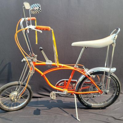 Sale Photo Thumbnail #17: Schwinn Sting-Ray Orange Krate with 5-speed Stik-Shift, springer front fork, high-rise handlebars, orange glitter grips, tall sissy bar, 1990's reproduction schwinn krate banana seat, original white letter slik rear tire, rear reflector, a PAIR of Schwinn