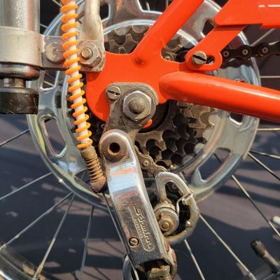Sale Photo Thumbnail #15: Schwinn Sting-Ray Orange Krate with 5-speed Stik-Shift, springer front fork, high-rise handlebars, orange glitter grips, tall sissy bar, 1990's reproduction schwinn krate banana seat, original white letter slik rear tire, rear reflector, a PAIR of Schwinn
