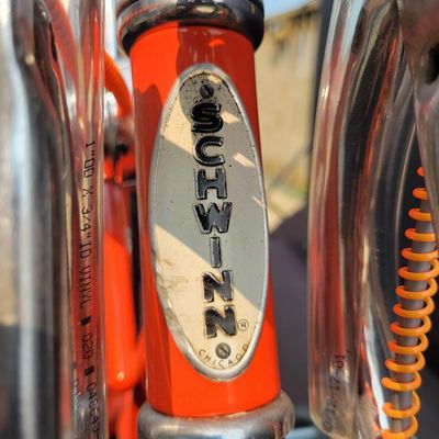 Sale Photo Thumbnail #16: Schwinn Sting-Ray Orange Krate with 5-speed Stik-Shift, springer front fork, high-rise handlebars, orange glitter grips, tall sissy bar, 1990's reproduction schwinn krate banana seat, original white letter slik rear tire, rear reflector, a PAIR of Schwinn