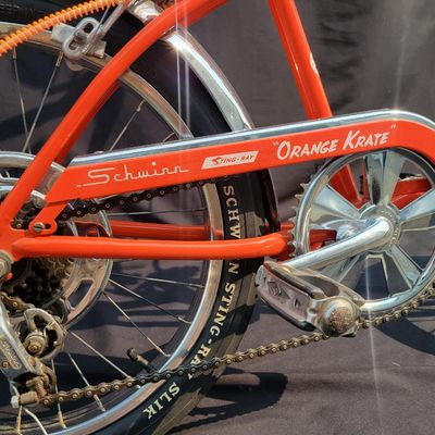 Sale Photo Thumbnail #3: Schwinn Sting-Ray Orange Krate with 5-speed Stik-Shift, springer front fork, high-rise handlebars, orange glitter grips, tall sissy bar, 1990's reproduction schwinn krate banana seat, original white letter slik rear tire, rear reflector, a PAIR of Schwinn