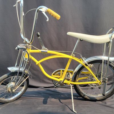 Sale Photo Thumbnail #27: Yellow Schwinn Sting-Ray Lemon Peeler Krate with 5-speed Stik-Shift, springer fork, Wide Tread rear tire, tall sissy bar,1990's reproduction yellow-and-white glitter banana seat, yellow grips and rear reflector. Attractive older frame repaint and decals, 
