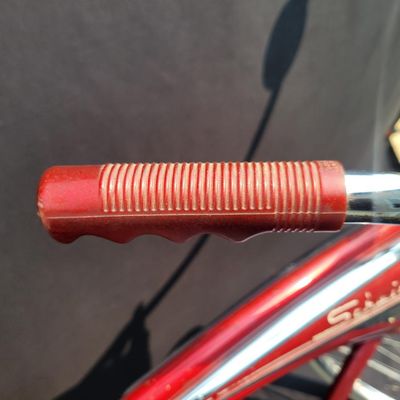 Sale Photo Thumbnail #117: Red Schwinn Jaguar with whitewall tires, full fenders, rear carrier, tank-style frame insert, red Mesinger-style saddle, bell, front light equipment and Jaguar-marked chainguard. The rear wheel sports a Bendix Red Band 2 speed Automatic Hub.  A nicely equ