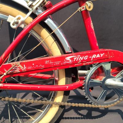 Sale Photo Thumbnail #133: Red Schwinn Deluxe Sting-Ray 3-speed with Deluxe Sting-Ray chainguard, high-rise handlebars, banana saddle, whhitewall Schwinn tires,  sissy bar, front fender and period internal-gear equipment. Honest unrestored condition with paint chips, decal wear, ch