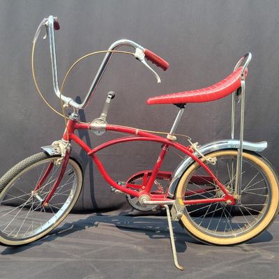 Sale Photo Thumbnail #140: Red Schwinn Deluxe Sting-Ray 3-speed with Deluxe Sting-Ray chainguard, high-rise handlebars, banana saddle, whhitewall Schwinn tires,  sissy bar, front fender and period internal-gear equipment. Honest unrestored condition with paint chips, decal wear, ch