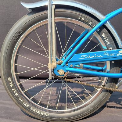Sale Photo Thumbnail #143: Blue Schwinn Deluxe Sting-Ray single speed coaster brake bicycle with blue banana seat, tall sissy bar, blue grips, high-rise handlebars, fenders and rear reflector. Very complete, original paint and attractive with moderate vintage wear to the saddle, gr