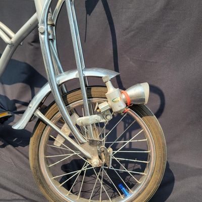 Sale Photo Thumbnail #160: 2004-era Schwinn Grey Ghost Sting-Ray factory reproduction, not an original 1971 Grey Ghost. Finished in silver/gray with chrome springer fork, 16-inch front and 20-inch rear wheels, Wald Ramshorn Handlebars,  Wide Tread rear tire, chrome fenders, striped