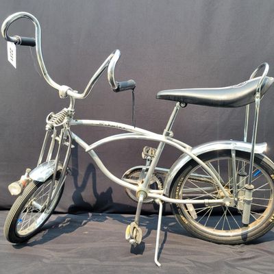Sale Photo Thumbnail #166: 2004-era Schwinn Grey Ghost Sting-Ray factory reproduction, not an original 1971 Grey Ghost. Finished in silver/gray with chrome springer fork, 16-inch front and 20-inch rear wheels, Wald Ramshorn Handlebars,  Wide Tread rear tire, chrome fenders, striped