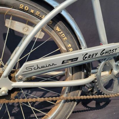 Sale Photo Thumbnail #157: 2004-era Schwinn Grey Ghost Sting-Ray factory reproduction, not an original 1971 Grey Ghost. Finished in silver/gray with chrome springer fork, 16-inch front and 20-inch rear wheels, Wald Ramshorn Handlebars,  Wide Tread rear tire, chrome fenders, striped