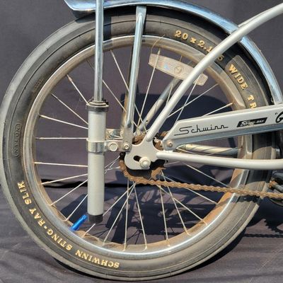 Sale Photo Thumbnail #158: 2004-era Schwinn Grey Ghost Sting-Ray factory reproduction, not an original 1971 Grey Ghost. Finished in silver/gray with chrome springer fork, 16-inch front and 20-inch rear wheels, Wald Ramshorn Handlebars,  Wide Tread rear tire, chrome fenders, striped