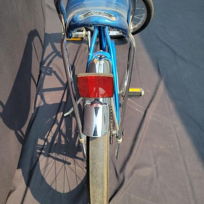 Sale Photo Thumbnail #172: Blue Schwinn Sting-Ray with banana saddle, tall sissy bar, high-rise handlebars, blue grips, chrome rear fender/reflector. Classic muscle-bike styling in good vintage condition with expected wear to the seat, grips, paint and chrome. Major components are 