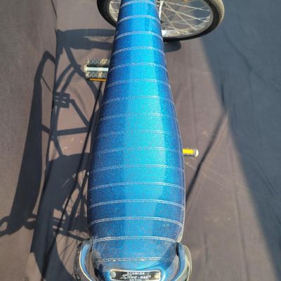 Sale Photo Thumbnail #173: Blue Schwinn Sting-Ray with banana saddle, tall sissy bar, high-rise handlebars, blue grips, chrome rear fender/reflector. Classic muscle-bike styling in good vintage condition with expected wear to the seat, grips, paint and chrome. Major components are 
