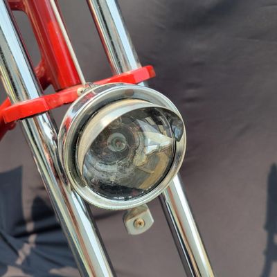 Sale Photo Thumbnail #216: Custom red 3-speed cargo tricycle with long wood-slatted rear cargo bed, tall handlebars, flame-style saddle, headlight, flags and assorted bottle/cargo accessories. Chainguard is marked “Ray Spoiler / 3 Speed.” A fun one-off custom build with strong 