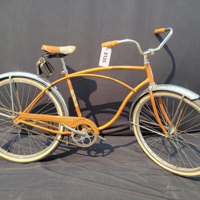 Sale Photo Thumbnail #236: Coppertone Schwinn Tiger with Tiger-marked chainguard, full fenders, brown saddle and bell. Classic mid-1960s Schwinn middleweight styling with good completeness and an attractive survivor look. Shows paint/chrome patina, saddle marks, aged tires and ligh