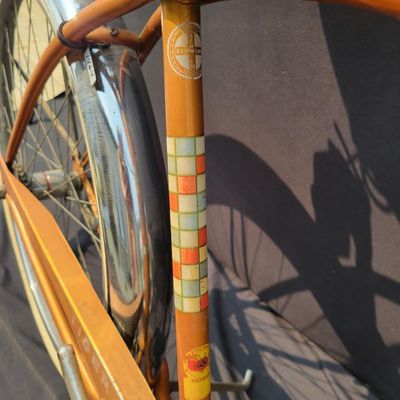 Sale Photo Thumbnail #238: Coppertone Schwinn Tiger with Tiger-marked chainguard, full fenders, brown saddle and bell. Classic mid-1960s Schwinn middleweight styling with good completeness and an attractive survivor look. Shows paint/chrome patina, saddle marks, aged tires and ligh