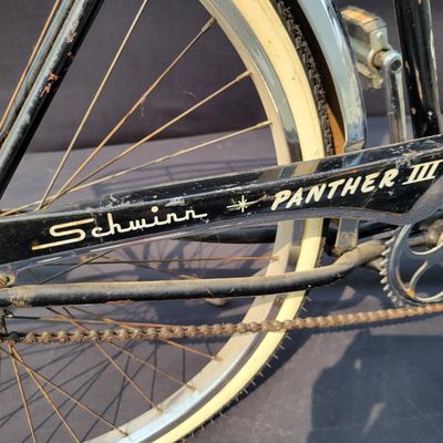 Sale Photo Thumbnail #245: Black Schwinn Panther III with chrome tank, full fenders, rear rack, whitewall tires and black/white saddle. Desirable deluxe Schwinn with excellent display presence and a largely complete configuration. Shows honest age including surface rust, paint wear