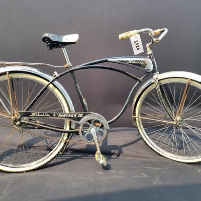 Sale Photo Thumbnail #244: Black Schwinn Panther III with chrome tank, full fenders, rear rack, whitewall tires and black/white saddle. Desirable deluxe Schwinn with excellent display presence and a largely complete configuration. Shows honest age including surface rust, paint wear