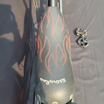 Sale Photo Thumbnail #285: Large adult-size Schwinn Sting-Ray Spoiler chopper with long springer/girder-style front end, black frame with red flame graphics, red wheels, fat rear tire, flame saddle, mirrors and headlamp-style accessories. Much larger and scarcer than the common you