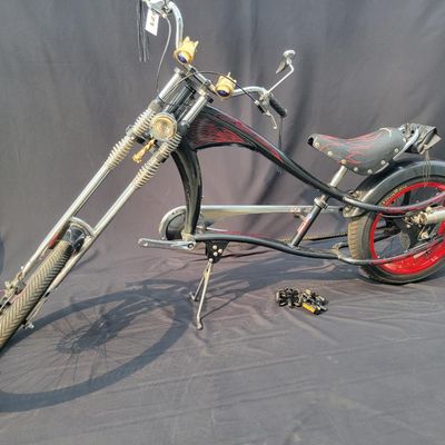 Sale Photo Thumbnail #289: Large adult-size Schwinn Sting-Ray Spoiler chopper with long springer/girder-style front end, black frame with red flame graphics, red wheels, fat rear tire, flame saddle, mirrors and headlamp-style accessories. Much larger and scarcer than the common you