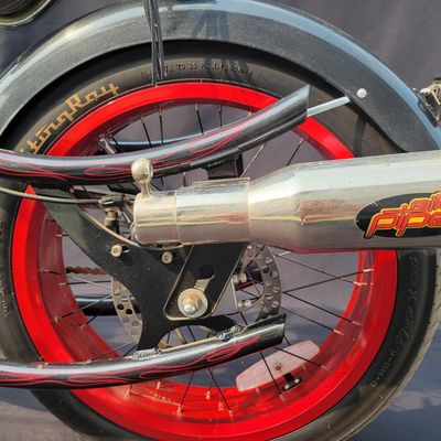 Sale Photo Thumbnail #288: Large adult-size Schwinn Sting-Ray Spoiler chopper with long springer/girder-style front end, black frame with red flame graphics, red wheels, fat rear tire, flame saddle, mirrors and headlamp-style accessories. Much larger and scarcer than the common you