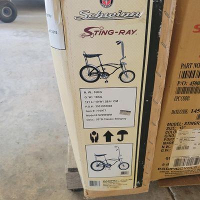 Sale Photo Thumbnail #313: Boxed Pacific Cycle-era Schwinn Classic Sting-Ray reproduction, model S2996WM, finished in black/chrome. Original-style factory carton is present and shows normal storage and handling wear. Bicycle remains boxed/unassembled and the contents have not been 