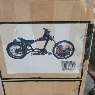Sale Photo Thumbnail #324: Boxed black Schwinn Sting-Ray chopper, model S2904, from the early-2000s Pacific Cycle era. Factory carton identifies a 20-inch boys Sting-Ray in black. Bicycle remains boxed/unassembled with normal shelf and handling wear to the carton. Contents have not