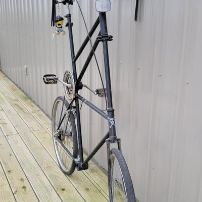 Sale Photo Thumbnail #333: One-of-a-kind custom tallbike built from stacked/welded bicycle frames and finished primarily in black. Fitted with multi-speed rear derailleur, front hand brake, high seating position and a full assortment of skull/pirate decorations, flags, tassels and 
