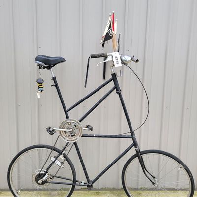 Sale Photo Thumbnail #332: One-of-a-kind custom tallbike built from stacked/welded bicycle frames and finished primarily in black. Fitted with multi-speed rear derailleur, front hand brake, high seating position and a full assortment of skull/pirate decorations, flags, tassels and 