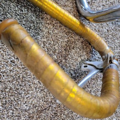 Sale Photo Thumbnail #349: Lot of two vintage bicycle handlebar assemblies: one chrome high-rise/ape-hanger bar with black Schwinn grips, plus one chrome set possibly from a Sears Screamer  with stem, dual brake levers and aged gold/yellow wrap. Both show typical use, scratches, ch