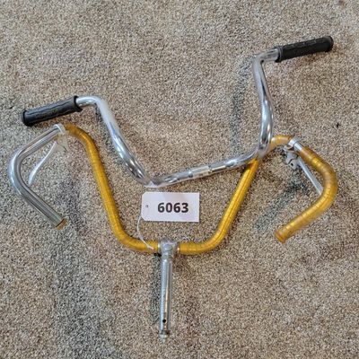 Sale Photo Thumbnail #347: Lot of two vintage bicycle handlebar assemblies: one chrome high-rise/ape-hanger bar with black Schwinn grips, plus one chrome set possibly from a Sears Screamer  with stem, dual brake levers and aged gold/yellow wrap. Both show typical use, scratches, ch