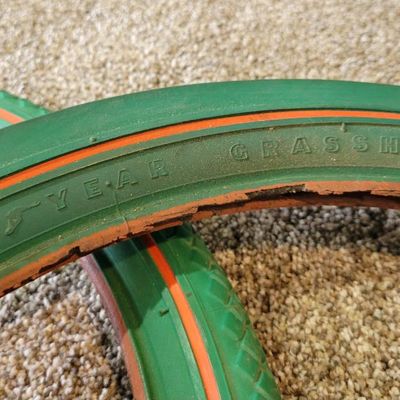 Sale Photo Thumbnail #372: Pair of vintage Goodyear green bicycle tires,Front Wingfoot size 20 x 1.75, and Rear Grasshopper Slick size 20 x 2.125 with contrasting orange/red sidewall stripe. Sidewalls are marked GOODYEAR and POLYESTER. Great visual fit for a vintage muscle-bike, cu