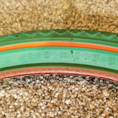 Sale Photo Thumbnail #374: Pair of vintage Goodyear green bicycle tires,Front Wingfoot size 20 x 1.75, and Rear Grasshopper Slick size 20 x 2.125 with contrasting orange/red sidewall stripe. Sidewalls are marked GOODYEAR and POLYESTER. Great visual fit for a vintage muscle-bike, cu