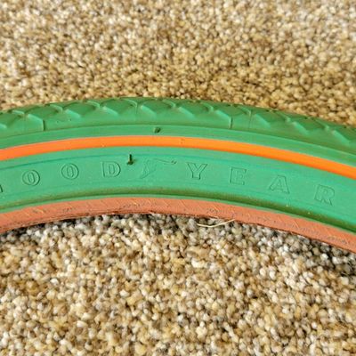 Sale Photo Thumbnail #376: Pair of vintage Goodyear green bicycle tires,Front Wingfoot size 20 x 1.75, and Rear Grasshopper Slick size 20 x 2.125 with contrasting orange/red sidewall stripe. Sidewalls are marked GOODYEAR and POLYESTER. Great visual fit for a vintage muscle-bike, cu