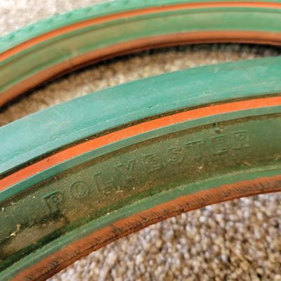 Sale Photo Thumbnail #371: Pair of vintage Goodyear green bicycle tires,Front Wingfoot size 20 x 1.75, and Rear Grasshopper Slick size 20 x 2.125 with contrasting orange/red sidewall stripe. Sidewalls are marked GOODYEAR and POLYESTER. Great visual fit for a vintage muscle-bike, cu