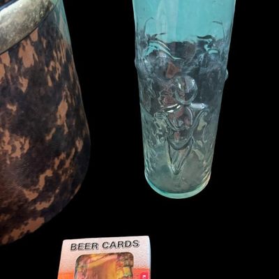 Sale Photo Thumbnail #320: Includes a mid-century NOS boxed set of novelty “What’ll Ya Have?” Bar jiggers and shot glasses made in Japan; a set of six “naughty” coasters; a Mabel’s Whore House glass mug; a vintage ice bucket; and more. Total of seven pieces.
