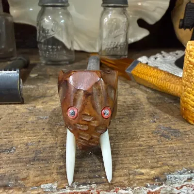 Sale Photo Thumbnail #274: Carved figural pipe with tusks and red eyes