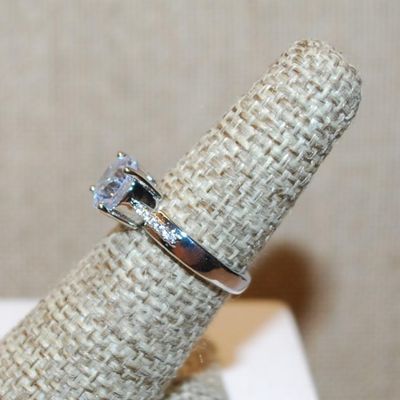 Size 6 Single Round Clear Stone Ring with Faint Line Accents on a Silver Tone Band (3.4g)
