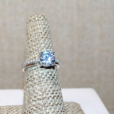 Size 6 Single Round Clear Stone Ring with Faint Line Accents on a Silver Tone Band (3.4g)