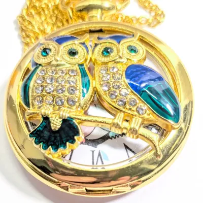 Sale Photo Thumbnail #20: Very Cute OWL POCKET WATCH with Blue/Green Feathers & Green Eyes, Gold Tone Setting and 30" L Chain/Lobster Clasp**EXTRA BATTERY INCLUDED**

QUARTZ
Non-rechargeable Battery
Brand: ALPHYNIX
Case Shape & Type: Round & Gold Colored
Display: Analog
Feature: S