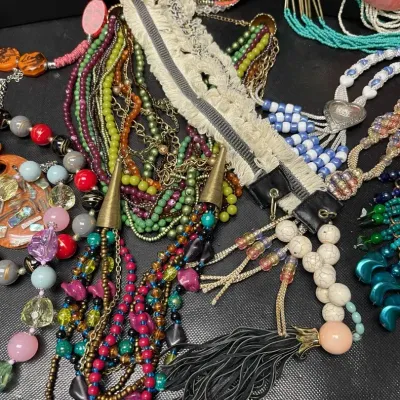 Sale Photo Thumbnail #156: Colorful statement necklace assortment featuring layered beads, seed beads, glass-look accents, shells, tassels, oversized pendants, and bold multistrand designs in a vibrant mix of Southwestern, bohemian, and eclectic styles.
