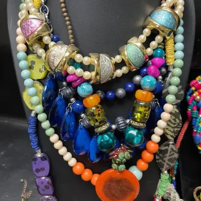 Sale Photo Thumbnail #155: Colorful statement necklace assortment featuring layered beads, seed beads, glass-look accents, shells, tassels, oversized pendants, and bold multistrand designs in a vibrant mix of Southwestern, bohemian, and eclectic styles.