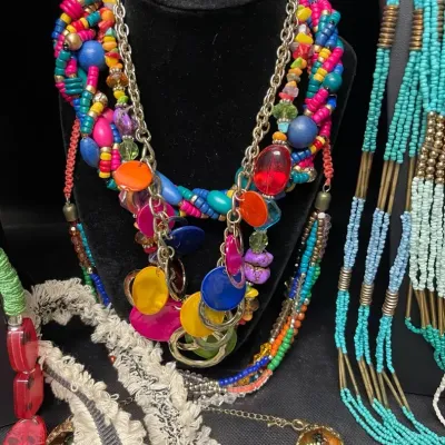 Sale Photo Thumbnail #378: Colorful statement necklace assortment featuring layered beads, seed beads, glass-look accents, shells, tassels, oversized pendants, and bold multistrand designs in a vibrant mix of Southwestern, bohemian, and eclectic styles.