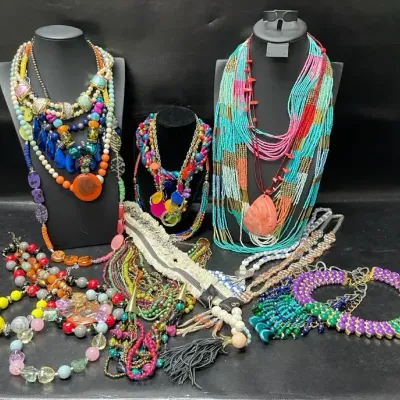 Sale Photo Thumbnail #377: Colorful statement necklace assortment featuring layered beads, seed beads, glass-look accents, shells, tassels, oversized pendants, and bold multistrand designs in a vibrant mix of Southwestern, bohemian, and eclectic styles.