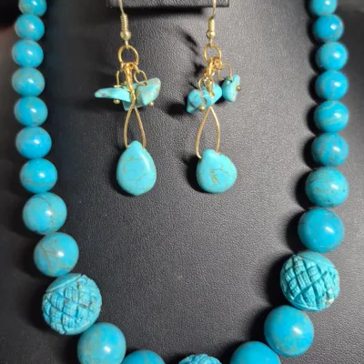 Sale Photo Thumbnail #417: turquoise or dyed turquoise-howlite beaded necklace and matching drop earring set featuring large, graduated round and carved melon beads
Earrings are turquoise chips strung on gold wire, pierced