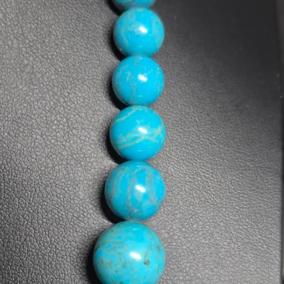 Sale Photo Thumbnail #419: turquoise or dyed turquoise-howlite beaded necklace and matching drop earring set featuring large, graduated round and carved melon beads
Earrings are turquoise chips strung on gold wire, pierced