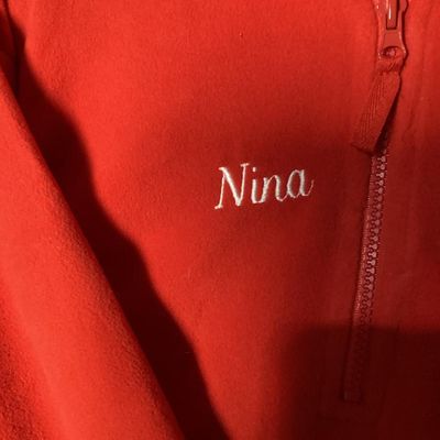 Sale Photo Thumbnail #5: NWT (New with tags) red fleece quarter-zip pullover from The Disney Store, featuring embroidered Minnie Mouse patch on the left chest and embroidered 'Nina' name detail on the right chest. 100% polyester fleece construction. Brand tags attached. Size: Lad