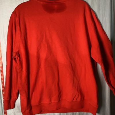 Sale Photo Thumbnail #13: Red long-sleeve crewneck sweatshirt featuring a center front embroidered and embellished reindeer applique with holiday light details. Measures approximately 28 to 29 inches in length as shown against the tape measure. Pre-owned condition with light signs